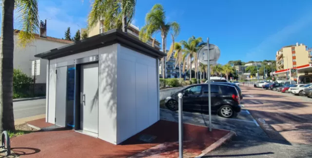 Openbare toiletten in lichtgrijs nabij een parkeerplaats