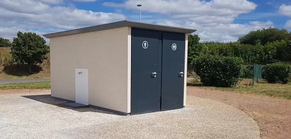 Dubbele sanitaire voorzieningen voor reizigersgemeenschappen in beige en grijs.