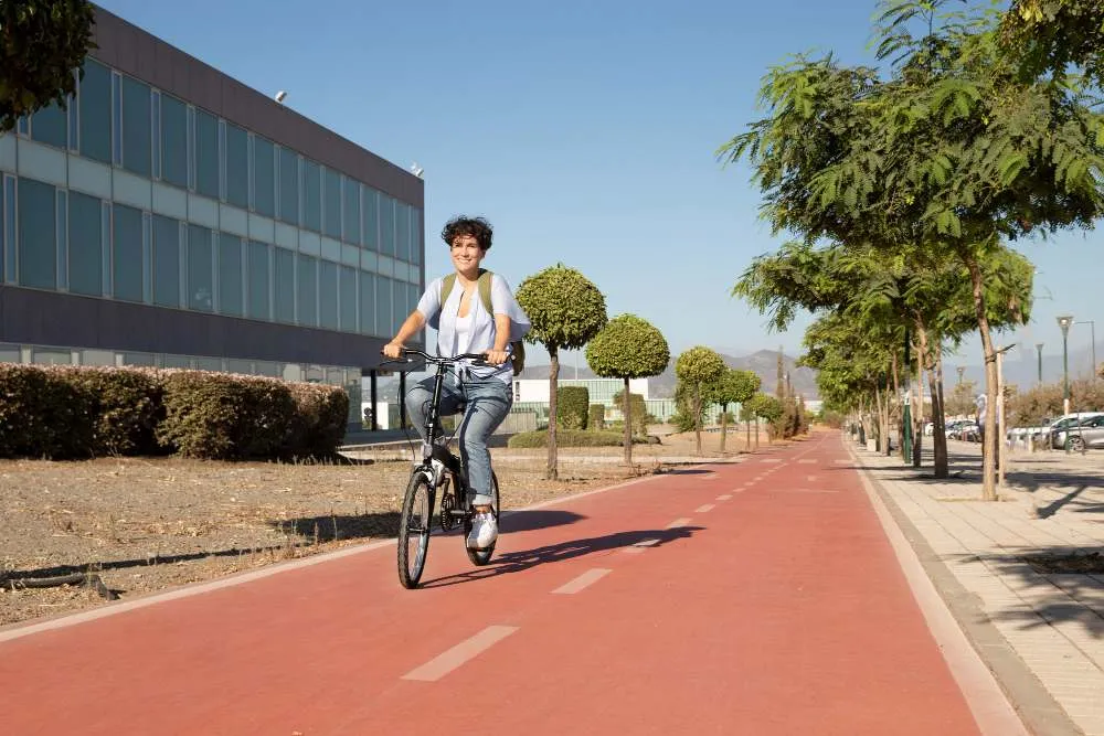 Junge Frau, die ihr faltbares Fahrrad benutzt