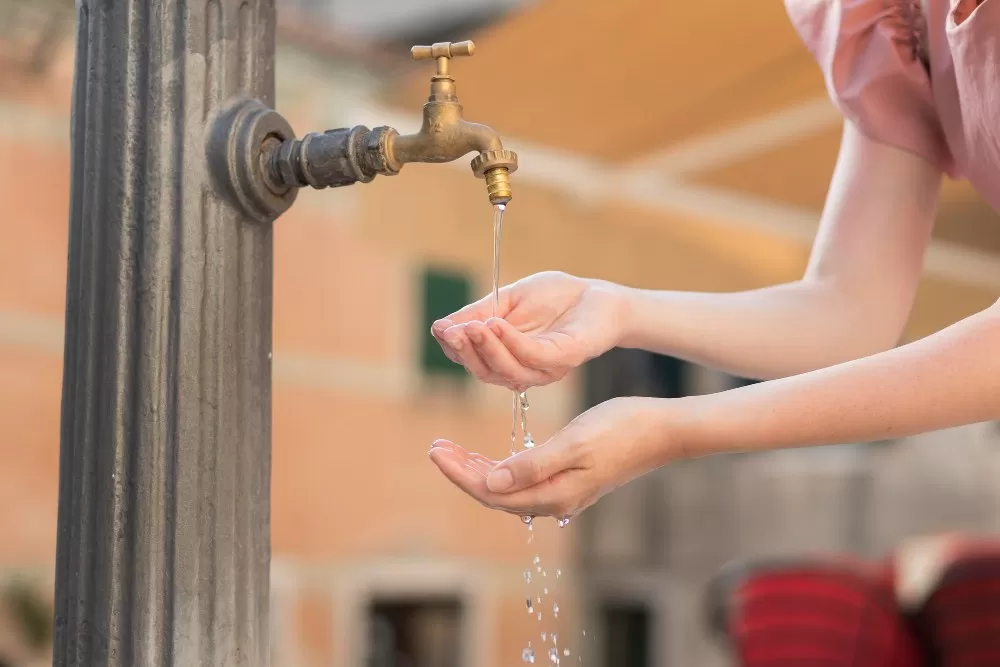 femme buvant de l'eau à une fontaine