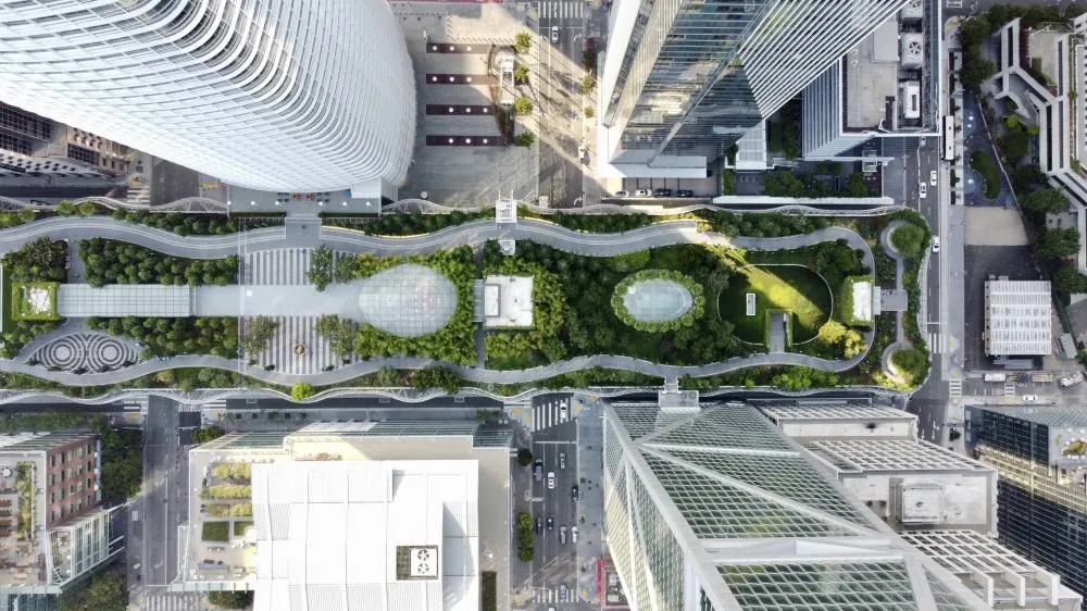 Vue aérienne d’un parc linéaire végétalisé au cœur d’un quartier d'une ville intelligente, avec cheminements piétons